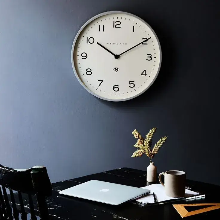 A minimalist clock in a bright, airy office space.